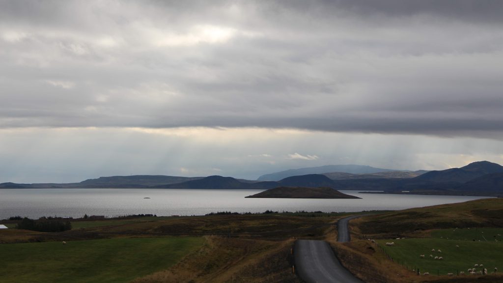 A scenic landscape of Iceland with sun rays, mountains and nature elements.